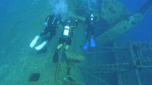 Three divers circling wreck at Akrotiri